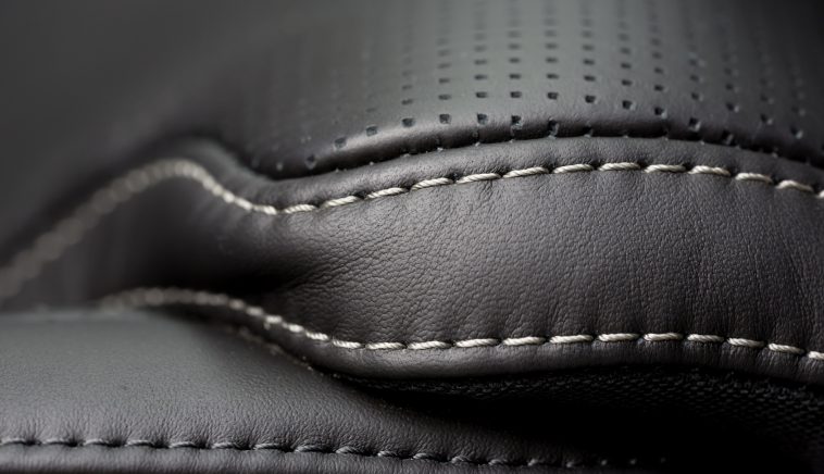 Black leather interior. Close up shot of stitches on a luxury car seat.